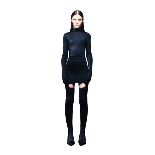 Person wearing a black outfit with long sleeves and a skirt on a white background