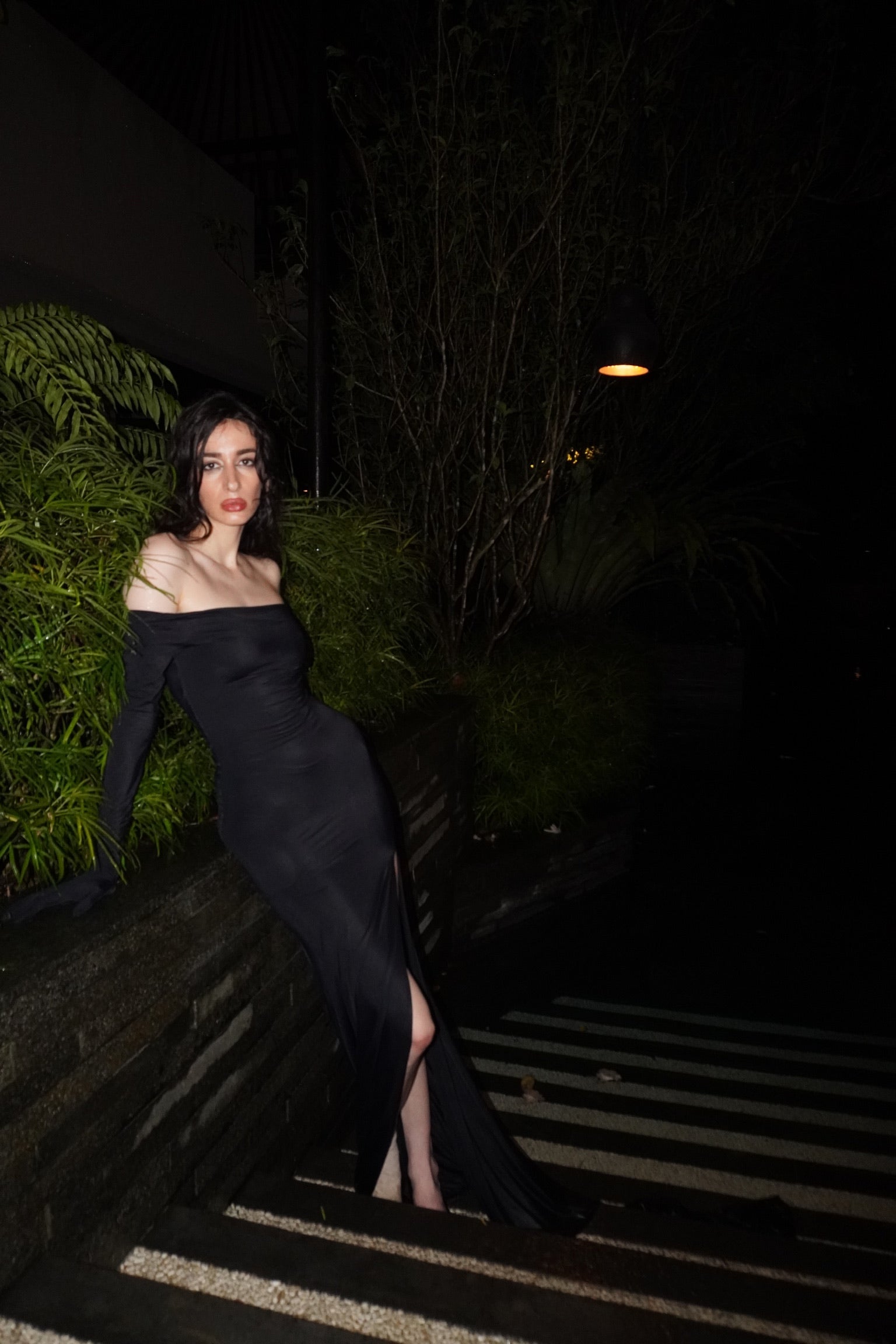 Black Hydra off-shoulder gown in ECONYL® technical jersey, worn on model.