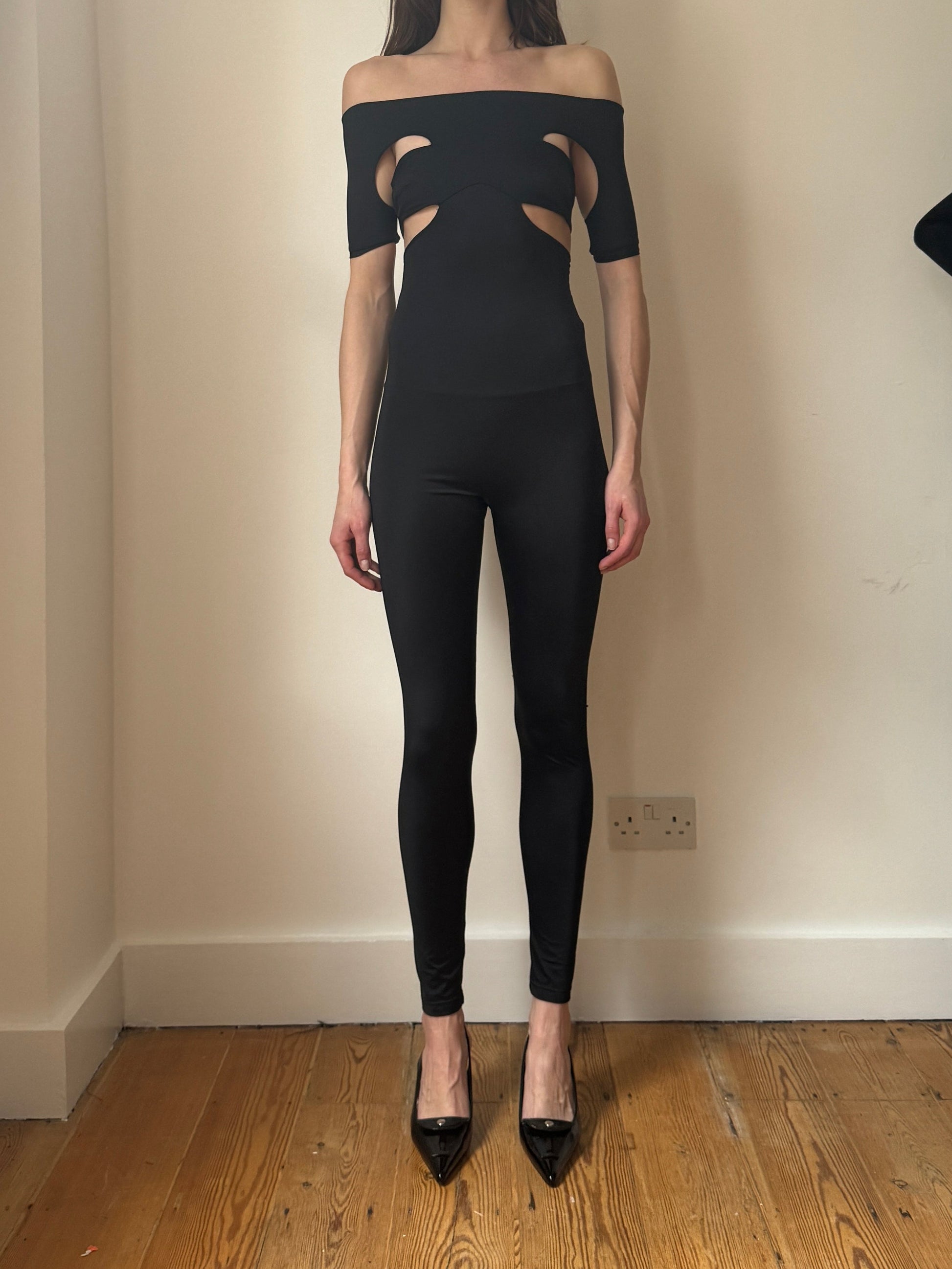 Black Echo jumpsuit in ECONYL® technical jersey, worn on model.